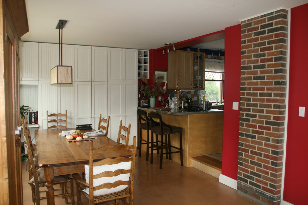 A dining room with a table and chairs, a brick wall