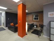 A room with orange walls and black furniture.