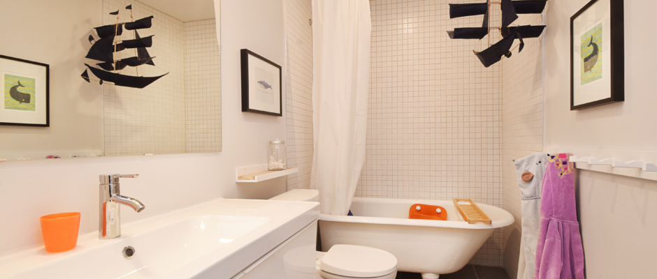 A bathroom with white tile and a tub