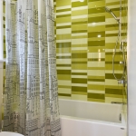 A bathroom with a shower curtain and tiled walls.