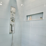 A bathroom with white walls and a shower.