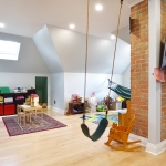 A room with a swing and a chair in it